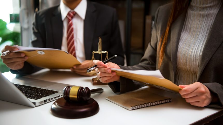 Business and lawyers discussing contract papers with brass scale Cuestionamientos a la gestión del BPS